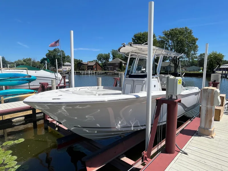 Slide: The Image of 2023 Sea Fox 248 Commander boat docked at a marina under clear blue skies. - 3