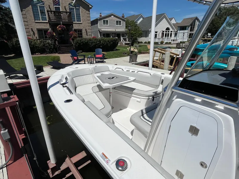Slide: The Image of 2023 Sea Fox 248 Commander boat docked near waterfront homes, showcasing spacious seating and sleek design. - 7