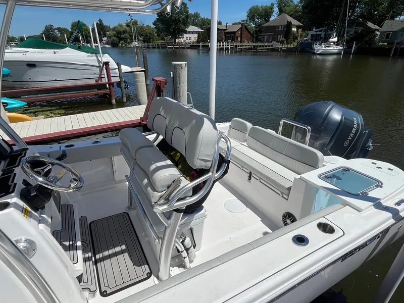 Slide: The Image of 2023 Sea Fox 248 Commander boat interior with seating and Yamaha engine, docked by a serene waterfront. - 9