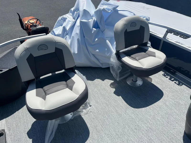 Slide: The Image of 2026 Sun Tracker Bass Buggy 18 DLX boat seats, gray upholstery, outdoor setting. - 7