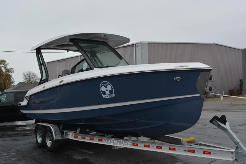 Slide: The Image of 2026 Monterey Elite 25 SD boat on trailer, parked outdoors near industrial buildings. - 6