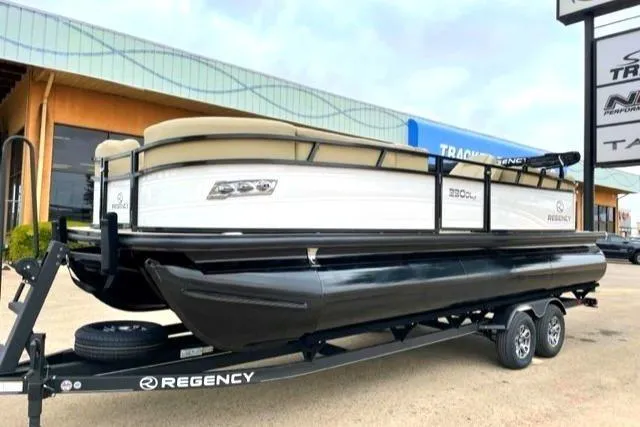 Slide: The Image of 2025 Regency 230 DL3 pontoon boat on trailer, displayed outdoors. - 0