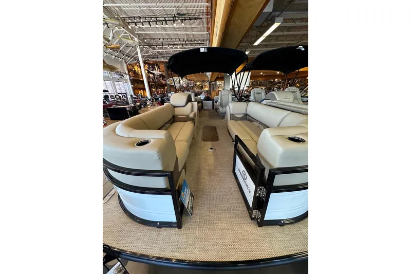 Slide: The Image of 2025 Regency 230 DL3 pontoon boat interior with beige seating and black canopy. - 4