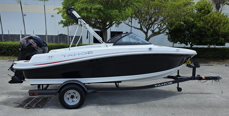 Slide: The Image of 2024 Tahoe 185 S boat on trailer, black and white design, parked outdoors. - 1