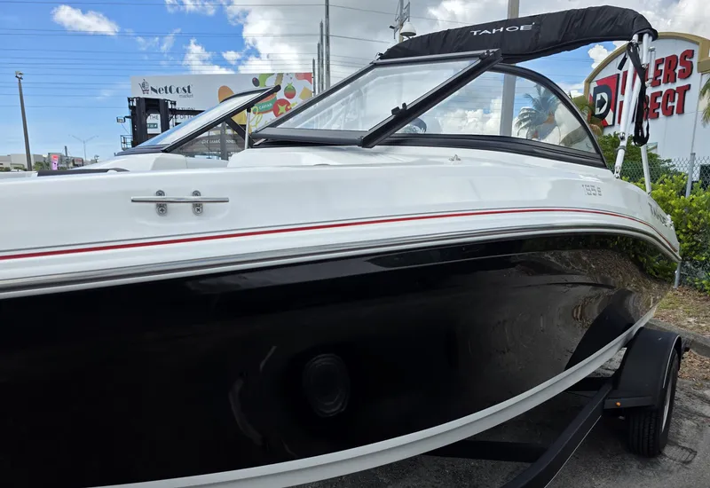 Slide: The Image of 2024 Tahoe 185 S boat with sleek black and white design, parked outdoors. - 3