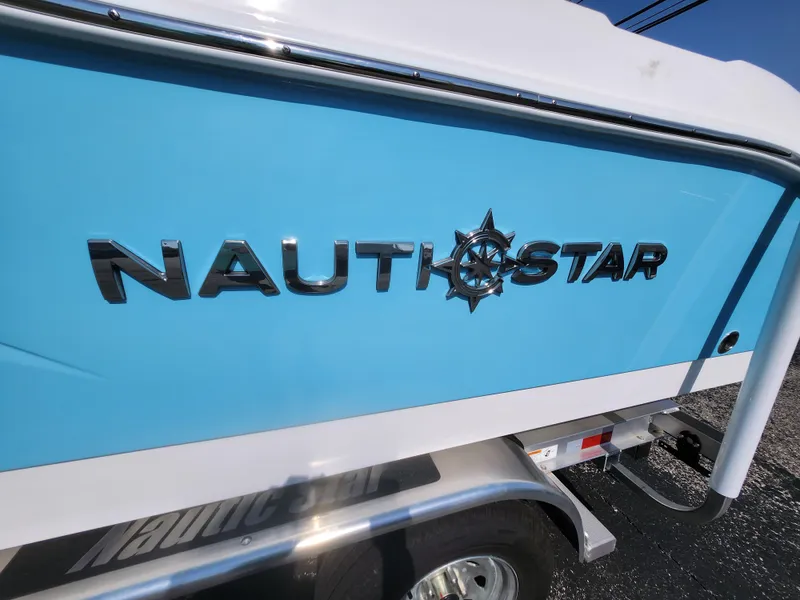 Slide: The Image of 2025 NauticStar 222 OSL boat with blue and white exterior on a trailer. - 13