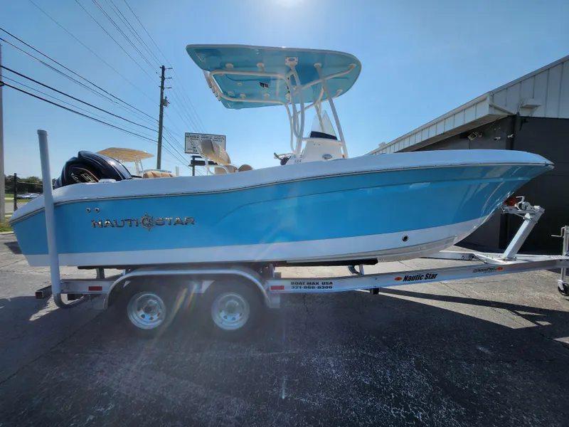 Slide: The Image of 2025 NauticStar 222 OSL boat on trailer, blue hull, sunny day. - 15