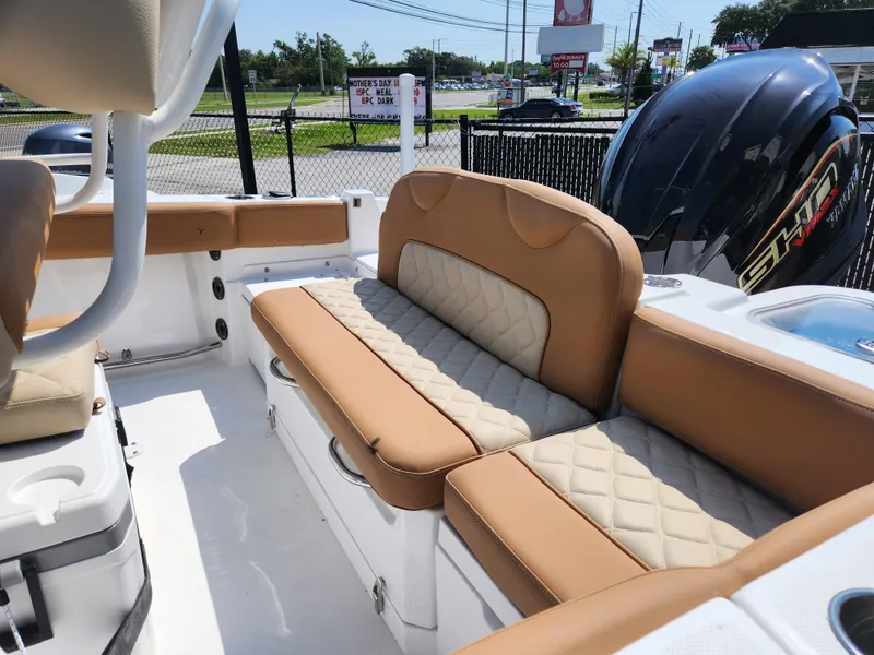 Slide: The Image of 2025 NauticStar 222 OSL boat interior with tan quilted seating and powerful engine. - 4