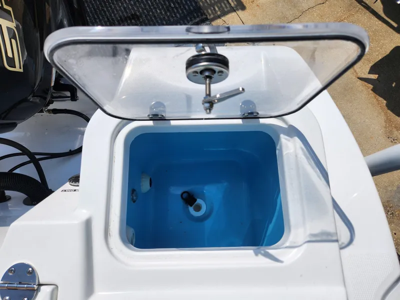 Slide: The Image of Open livewell on 2025 NauticStar 222 OSL boat, featuring a clear lid and blue interior. - 5