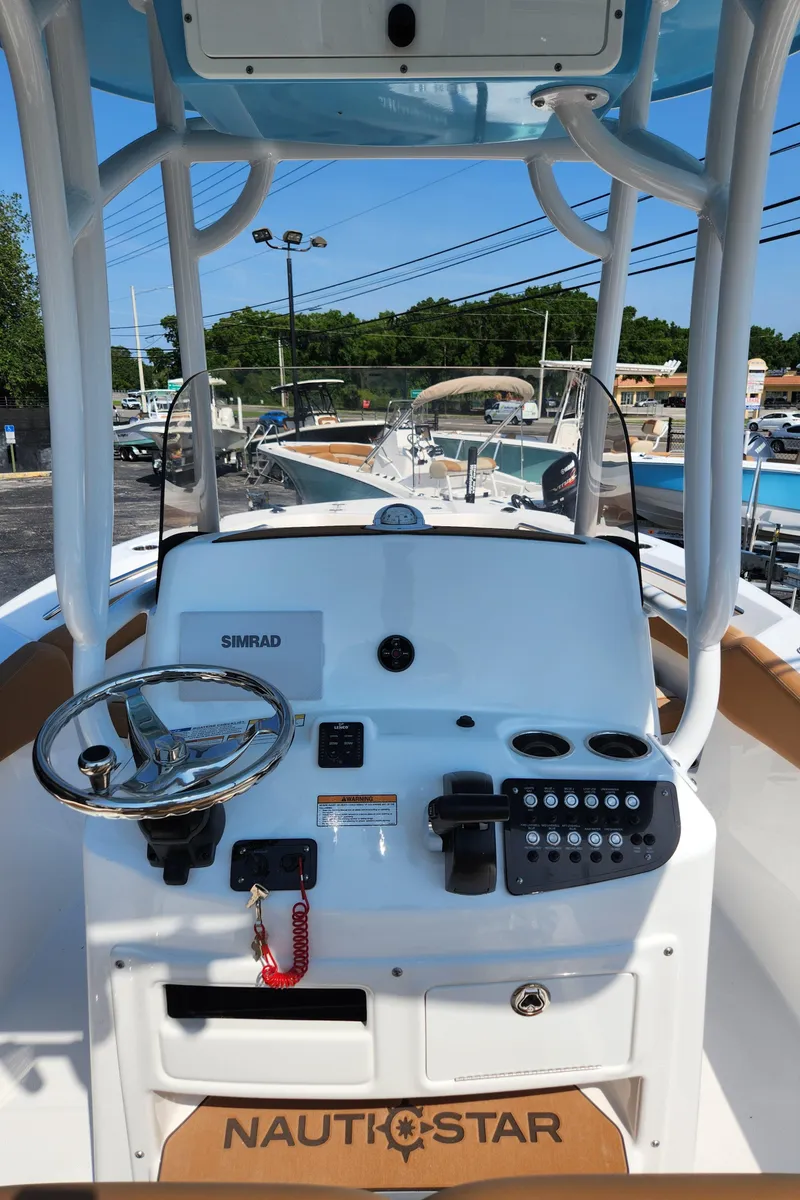 Slide: The Image of 2025 NauticStar 222 OSL boat dashboard with steering wheel and controls. - 7
