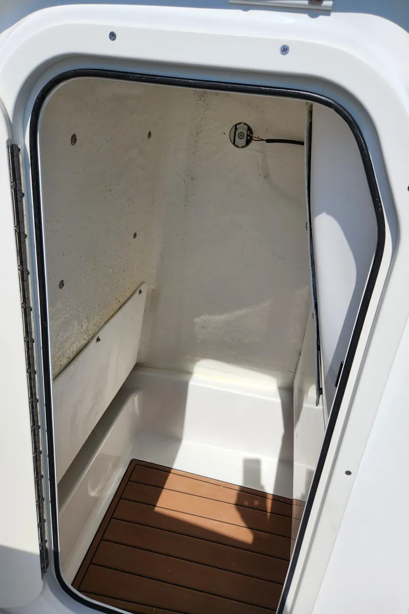 Slide: The Image of 2025 NauticStar 222 OSL boat storage compartment with wooden flooring. - 9