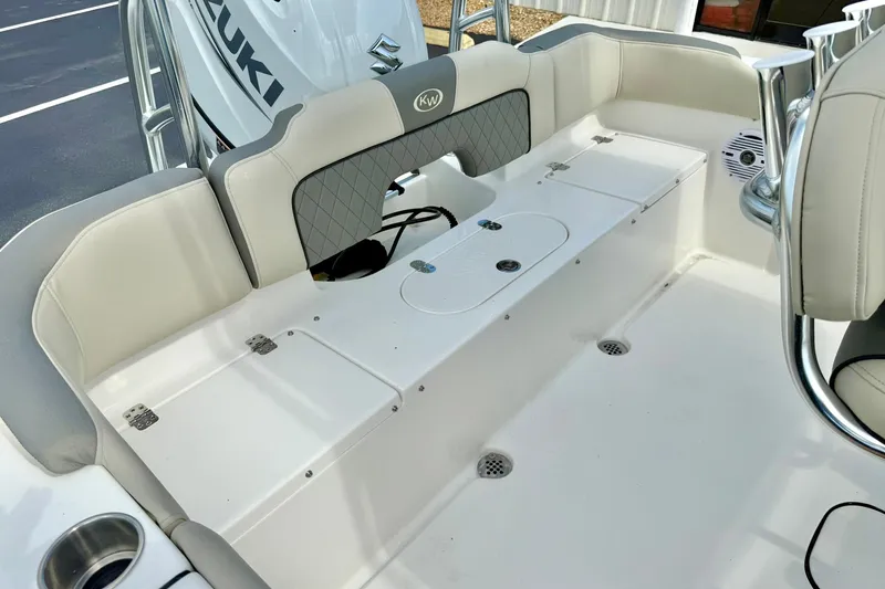 Slide: The Image of 2025 Key West 203 FS boat interior with Suzuki engine, featuring white seating and storage compartments. - 25