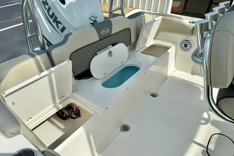 Slide: The Image of 2025 Key West 203 FS boat interior with storage compartments and Suzuki engine. - 26