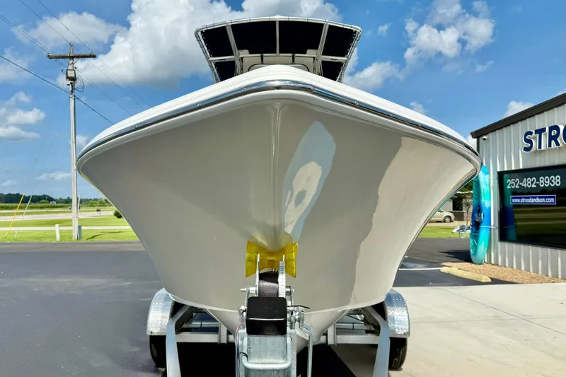 Slide: The Image of 2025 Key West 203 FS boat on trailer, parked outside dealership under blue sky. - 7