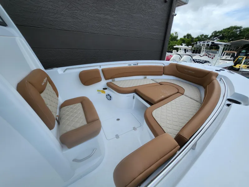 Slide: The Image of 2026 NauticStar 252 Legacy boat interior with tan and white cushioned seating. - 12