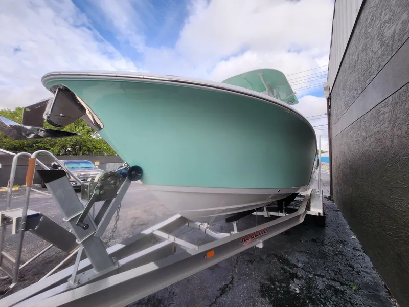 Slide: The Image of 2026 NauticStar 252 Legacy boat on trailer, side view under cloudy sky. - 15