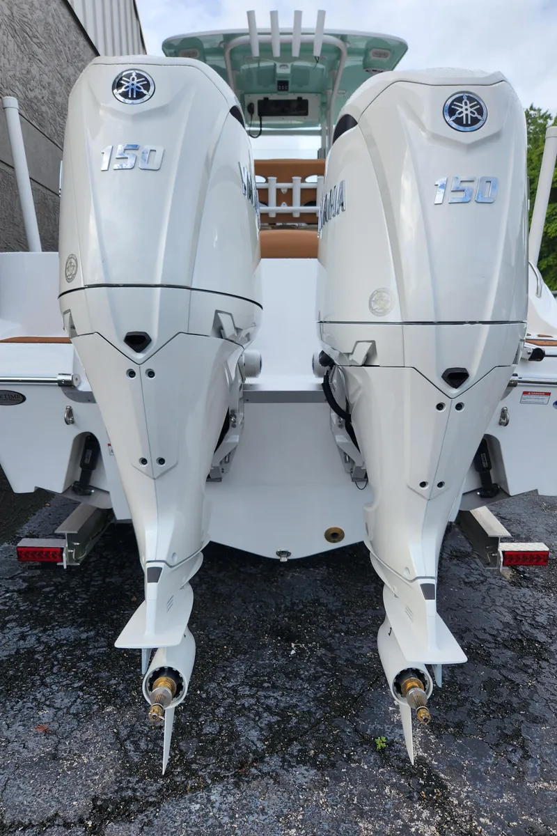 Slide: The Image of 2026 NauticStar 252 Legacy with dual 150 horsepower outboard engines, rear view. - 3