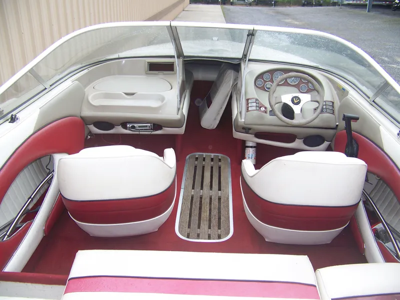 Slide: The Image of 1996 Bayliner 1850SS boat interior with red and white seating, steering wheel, and dashboard. - 3