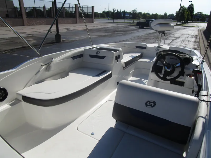 Slide: The Image of 2022 Hurricane SS 185 boat interior with seating and steering wheel in a parking lot. - 6