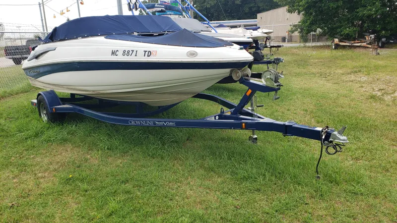 The Image of 2009 Crownline 18SS boat on trailer, covered, parked on grass. - 1