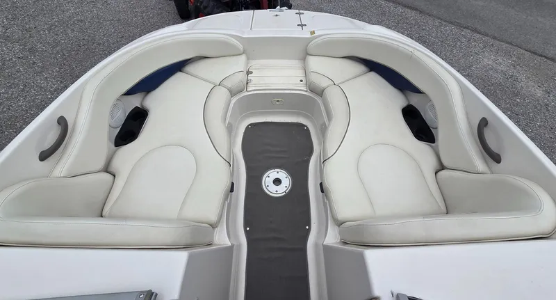 Slide: The Image of 2004 Monterey 233 Explorer boat interior with white cushioned seating and cup holders. - 10
