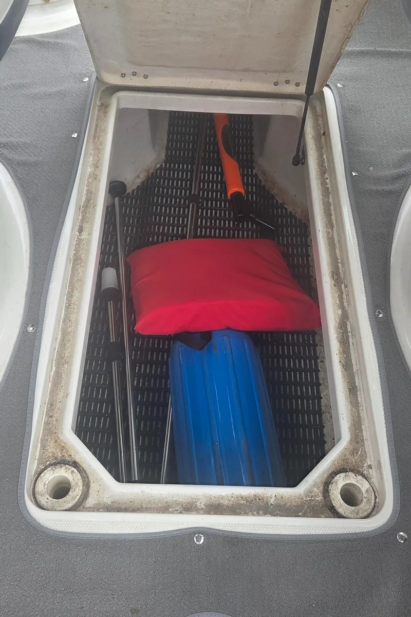 Slide: The Image of Open storage compartment in a 2004 Monterey 233 Explorer boat with boating gear. - 14
