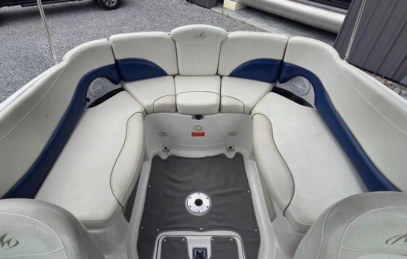 Slide: The Image of 2004 Monterey 233 Explorer boat interior with white and blue seating arrangement. - 6