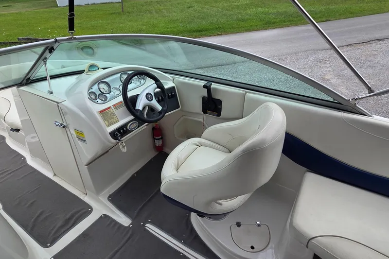 Slide: The Image of 2004 Monterey 233 Explorer boat interior with steering wheel and captain's chair. - 7