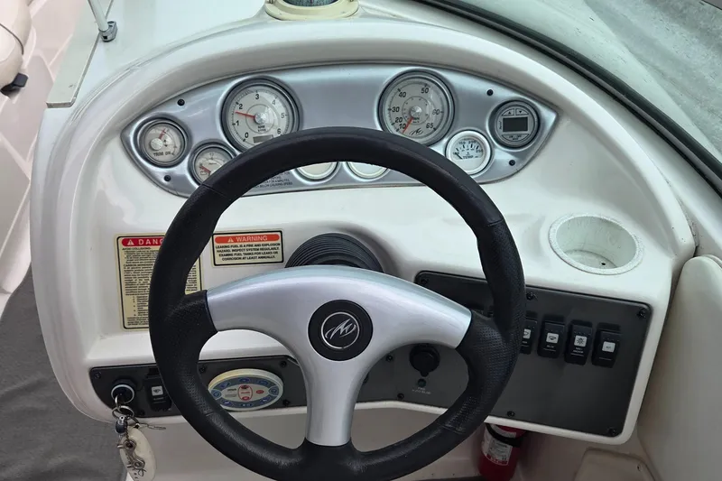 Slide: The Image of Steering wheel and dashboard of 2004 Monterey 233 Explorer boat with gauges and controls. - 8