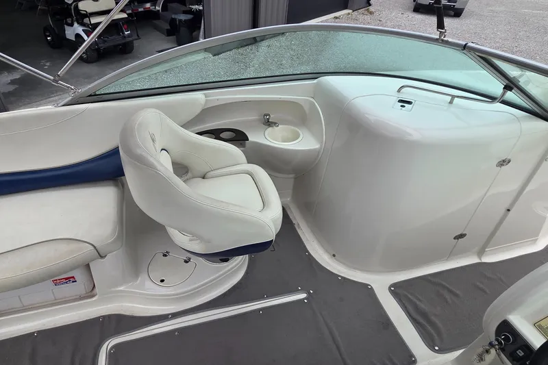 Slide: The Image of 2004 Monterey 233 Explorer boat interior with white seating and console. - 9