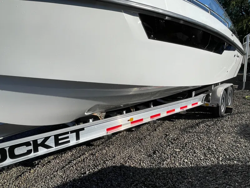 Slide: The Image of 2023 Yamarin 88 DC boat on a trailer, parked on gravel. - 10