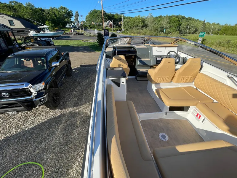Slide: The Image of 2023 Yamarin 88 DC boat interior with tan seating, parked near a black truck. - 13