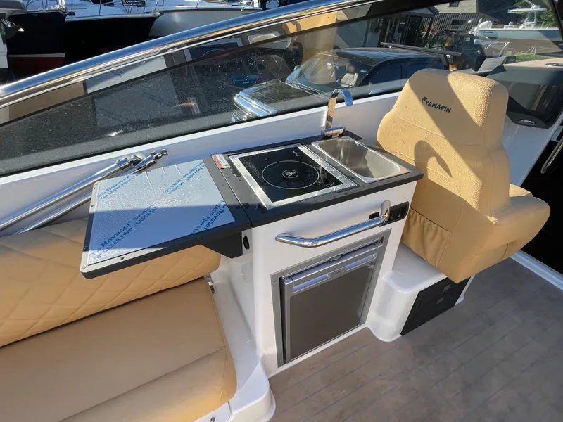Slide: The Image of 2023 Yamarin 88 DC boat interior with kitchenette and seating area. - 17