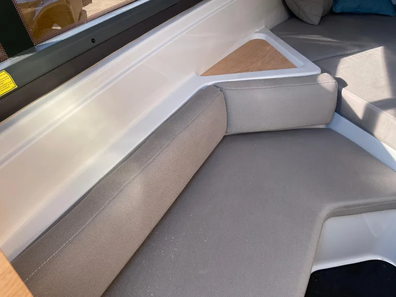 Slide: The Image of Interior seating of 2023 Yamarin 88 DC boat with beige cushions and wooden accents. - 23