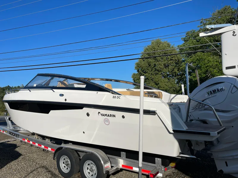 Slide: The Image of 2023 Yamarin 88 DC boat on trailer, clear blue sky background. - 3