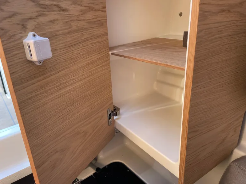 Slide: The Image of Open wooden cabinet in 2023 Yamarin 88 DC boat interior, showcasing storage space. - 31