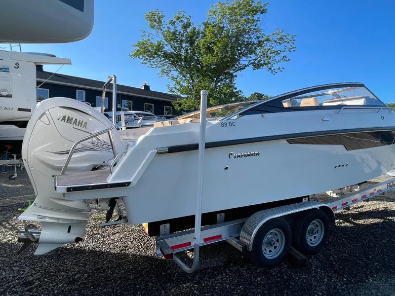Slide: The Image of 2023 Yamarin 88 DC boat on trailer with Yamaha engine, parked outdoors. - 7