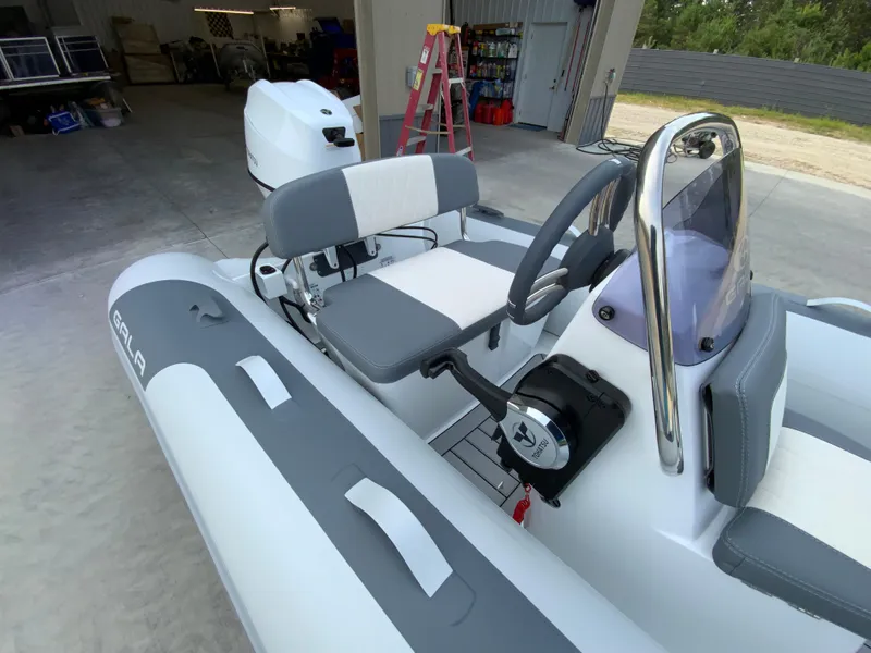 Slide: The Image of 2026 Gala A330L inflatable boat interior with steering console and seating in a garage setting. - 7