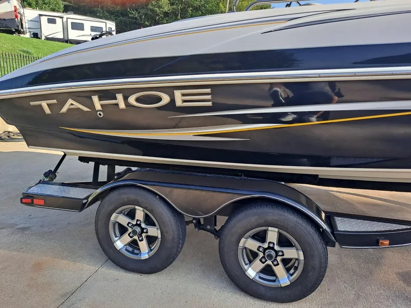 Slide: The Image of 2010 Tahoe 195 Deckboat on trailer, side view with logo and dual wheels. - 2