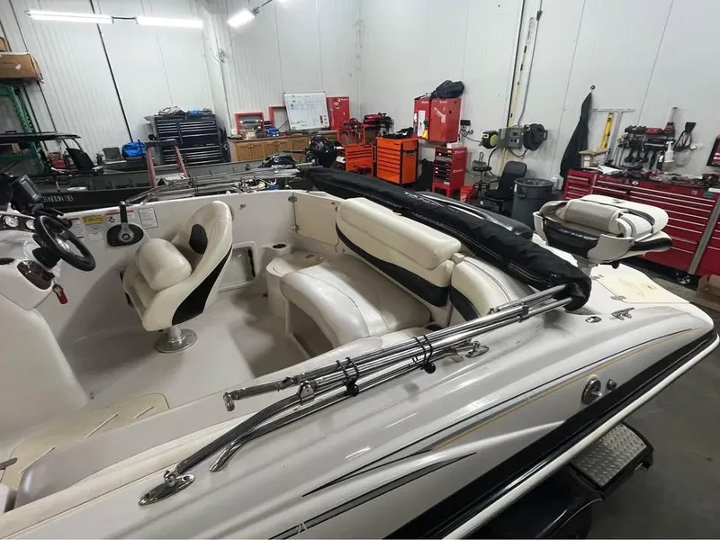 Slide: The Image of 2010 Tahoe 195 Deckboat in a workshop, featuring white seating and steering wheel. - 3