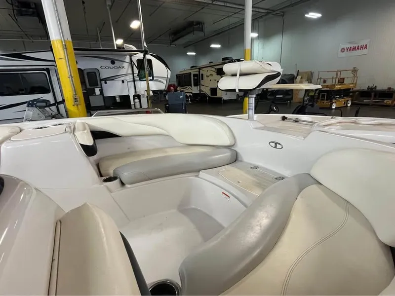 Slide: The Image of 2010 Tahoe 195 Deckboat interior with white seating in a storage facility. - 5