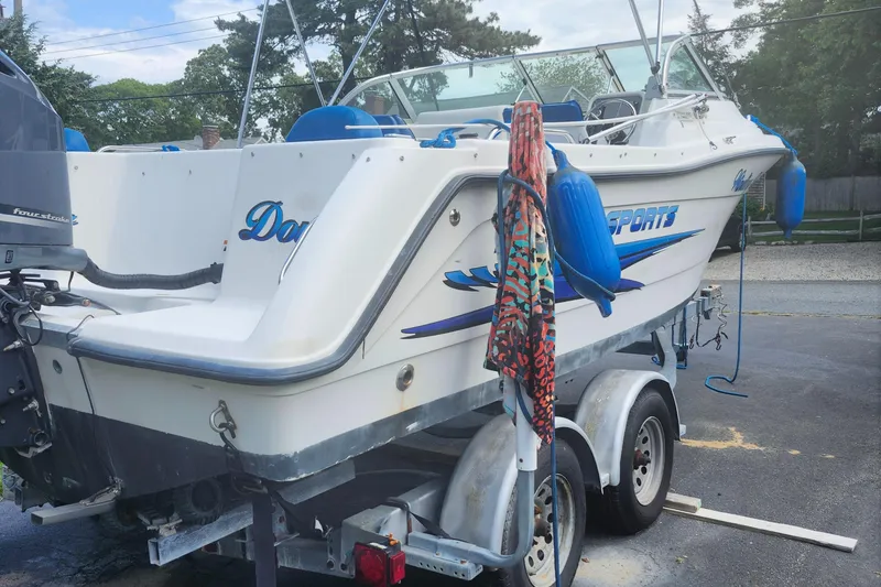 Slide: The Image of 2006 Hydra-Sports 202 DC boat on trailer, parked outdoors with colorful towel and blue fenders. - 3