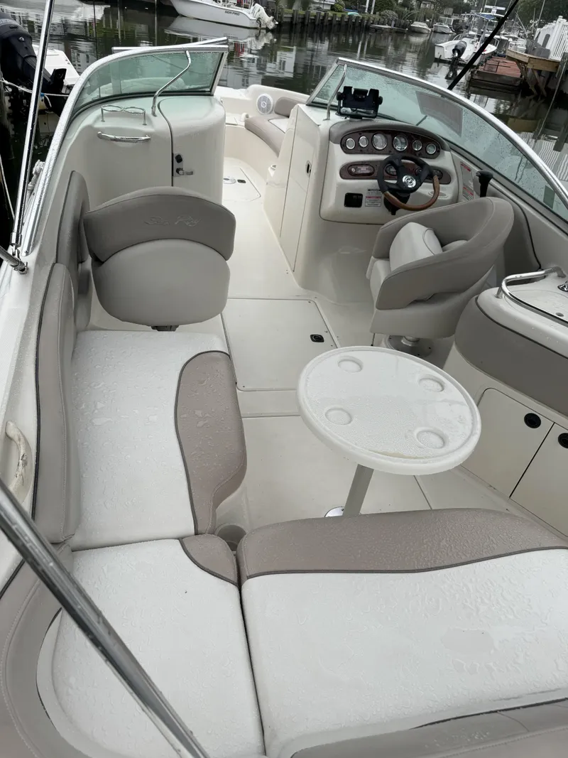 Slide: The Image of 2004 Sea Ray 240 Sundeck interior with seating and helm, docked at marina. - 4