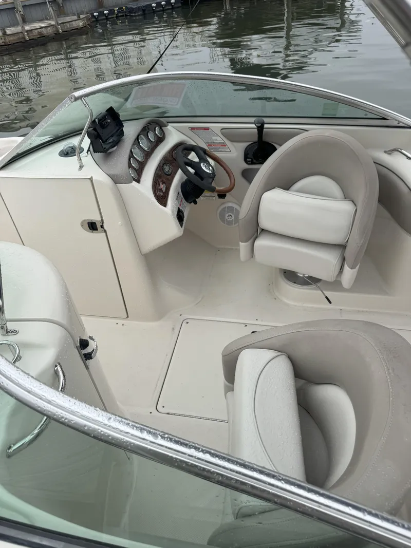 Slide: The Image of 2004 Sea Ray 240 Sundeck boat interior with steering wheel and seating. - 7