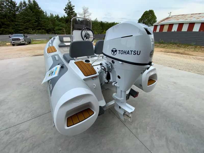 Slide: The Image of 2026 Gala V330 boat with Tohatsu engine, parked outdoors on concrete surface. - 2