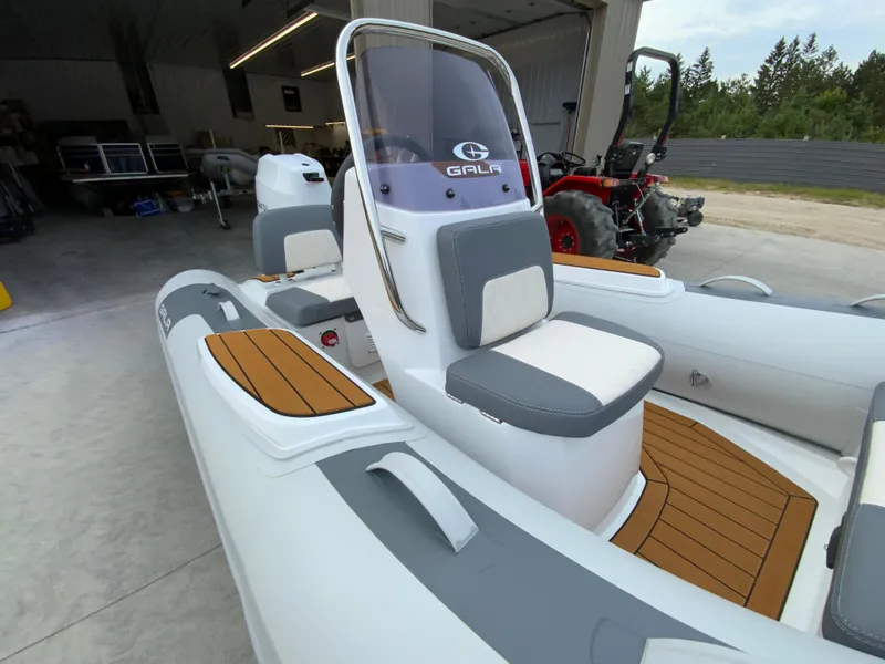 Slide: The Image of 2026 Gala V330 boat with sleek design and comfortable seating in a garage setting. - 7