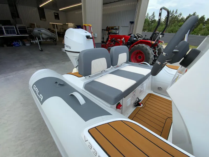 Slide: The Image of 2026 Gala V330 inflatable boat with Tohatsu engine in a garage setting. - 9