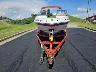 Slide: The Image of 2008 Crownline 19 SS boat on trailer, parked on asphalt, with grassy hills in background. - 5