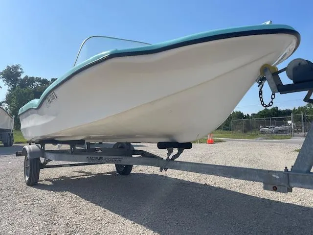 Slide: The Image of 1959 Glastron 15' Surflite boat on trailer, parked outdoors on a sunny day. - 2