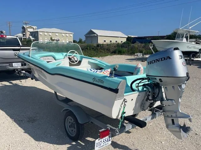 Slide: The Image of 1959 Glastron 15' Surflite boat with Honda motor on trailer, parked outdoors. - 3